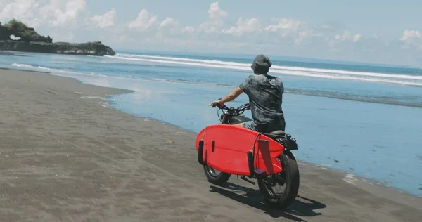 Motorkář řízení jeho motocykl na pláži — Stock fotografie