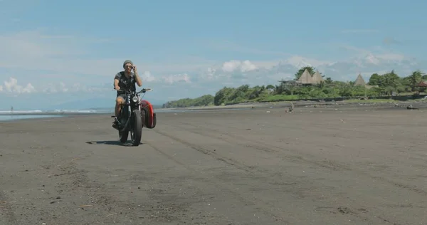 Motorrijder rijdt zijn motor op het strand — Stockfoto