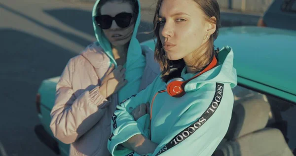 Woman sitting on longboard while her friend pushing her behind — Stock Photo, Image