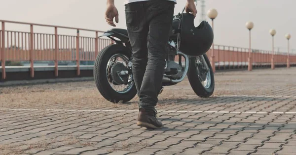 Le gars marche à travers le parking jusqu'à sa moto — Photo
