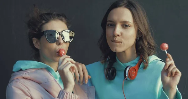 Duas lindas meninas chupando pirulitos — Fotografia de Stock