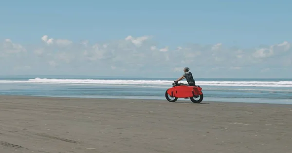 Sahilde motosikletini süren bir motosikletli. — Stok fotoğraf