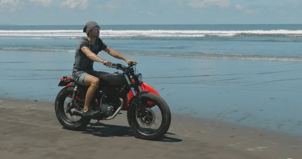 Motorrijder rijdt zijn motor op het strand — Stockfoto