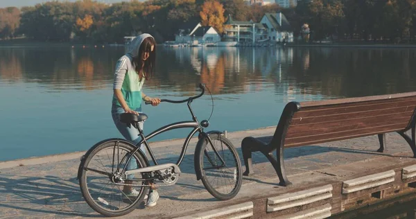 Женщина или девушка на велосипеде по набережной — стоковое фото
