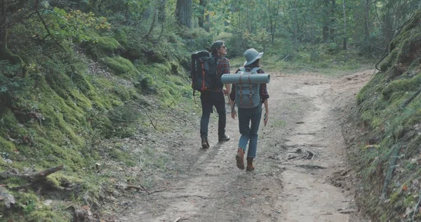 Jonge man en vrouw wandelen in het bos — Stockfoto