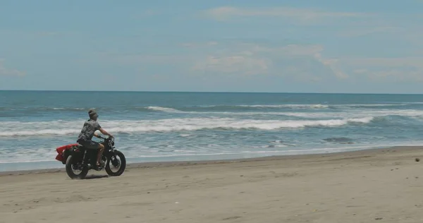 Motocyklista prowadzący motocykl na plaży — Zdjęcie stockowe