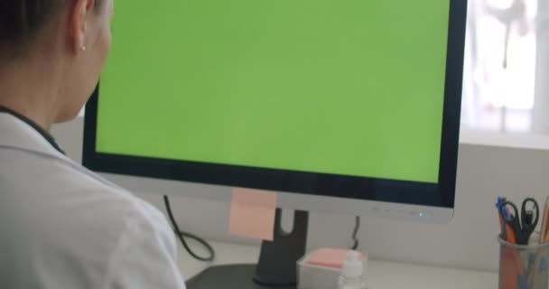Doctor work on computer with green mock-up screen — Stock Video