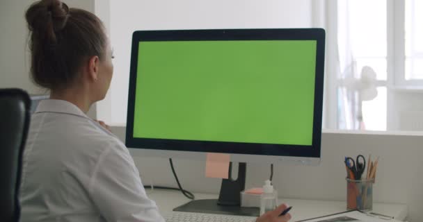 Doctor work on computer with green mock-up screen — Stock Video