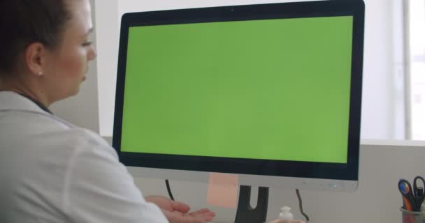 緑のモックアップ画面を持つコンピュータ上の医師の仕事 — ストック動画