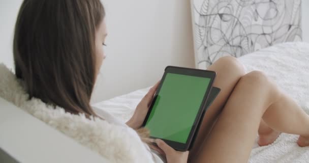 Девушка держит планшетный компьютер с зеленым экраном — стоковое видео