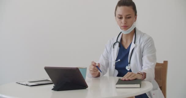 Tablette çalışan beyaz önlüklü doktor. — Stok video