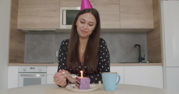 Mujer en partido casquillo enciende vela en un pastel — Vídeos de Stock
