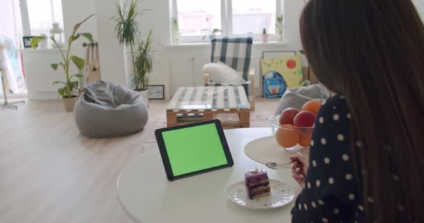 Frau benutzt ihr Tablet mit grünem Bildschirm — Stockvideo