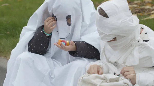 Niños con disfraces de momia y fantasma comparten dulces —  Fotos de Stock