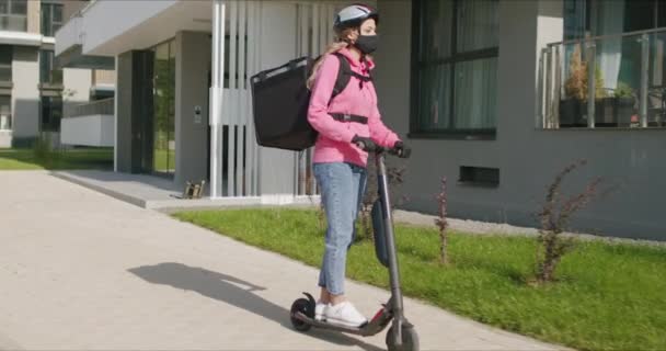 Курьер по доставке быстрого питания ездит на электрическом скутере — стоковое видео