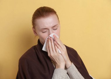 Kız sarı arka planda hapşırır