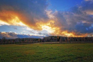 Sonbahar yatay, Kuru otların arasında ayar güneş tarafından aydınlatılmış bulutlar ile orman ve günbatımı gökyüzü arka plan üzerinde çayır