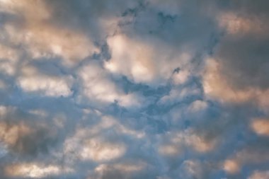 mavi gök tüylü bulutlarda ayarlama ufukta güneş ışınlarının tarafından aydınlatılmış