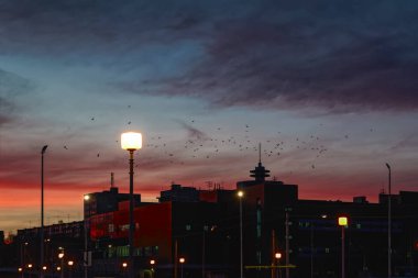 Bulutlar gökyüzünde Güneşin ufukta ayarlama ışınları tarafından aydınlatılmış