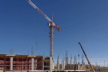 Mavi yaz göğün bir arka plan üzerinde bir alışveriş merkezi inşaatı vinç