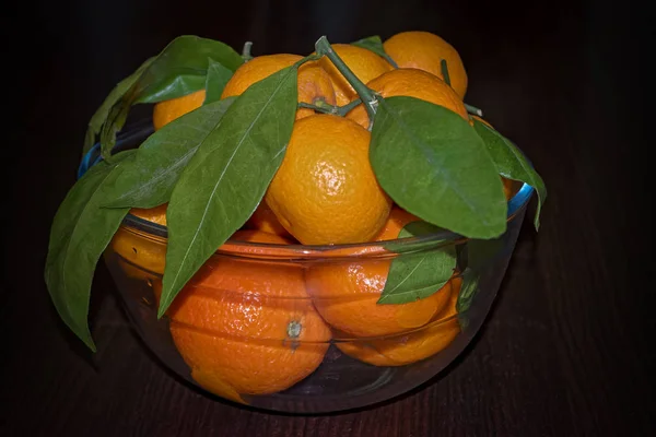 Mandarinas Con Hojas Una Placa Vidrio Sobre Fondo Rústico Madera —  Fotos de Stock