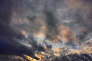 Gökyüzü mavi ve turuncu ışık kış gökyüzündeki bulutların arasından güneş