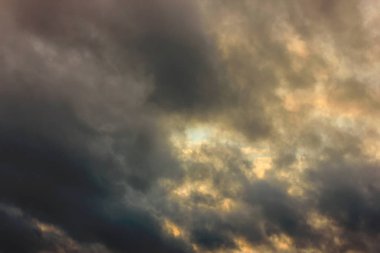 Gökyüzü mavi ve turuncu ışık kış gökyüzündeki bulutların arasından güneş