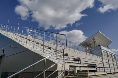 Mavi yaz gökyüzüne karşı stadyumun boş standları