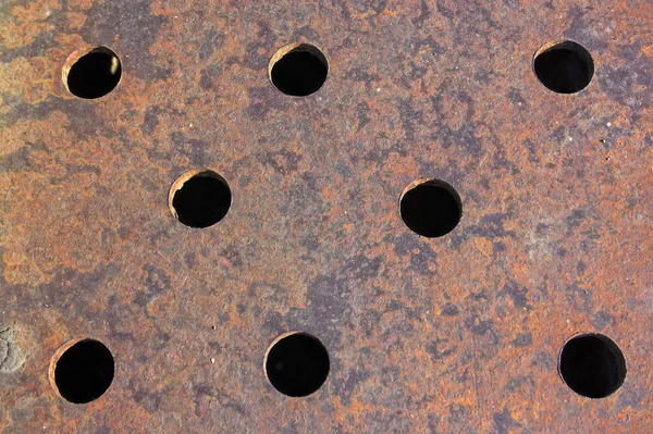 穴アップでさびた金属シートの質感 — ストック写真