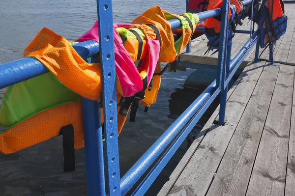 Gilets de sauvetage sur les mains courantes du poste d'amarrage pour bateaux — Photo