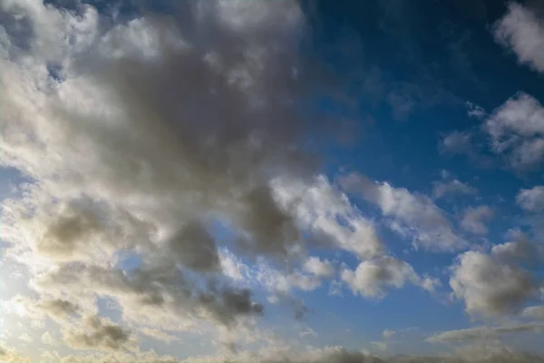 Cielo azul con nubes de oro - puesta de sol dramática, hermoso fondo natural. El sol poniente ilumina las nubes . — Foto de Stock