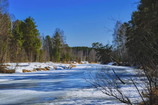 Vroege voorjaar ijs smelt op een klein bos-rivier — Stockfoto