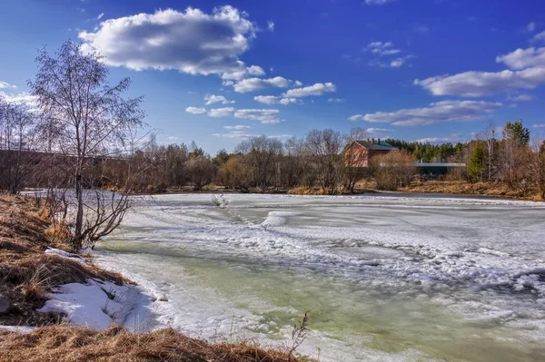 Paisagem de primavera derrete gelo em um pequeno rio na borda da aldeia . — Fotografia de Stock