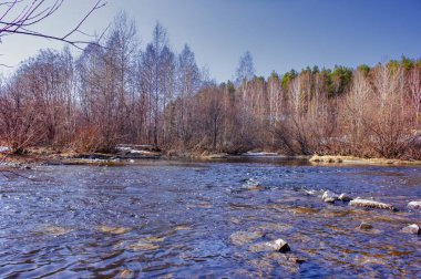 Erken Ilkbahar manzarası, köyün kenarındaki küçük bir nehirde buz eritir.