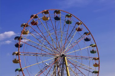 dönme dolap mavi gökyüzü karşı parkta.