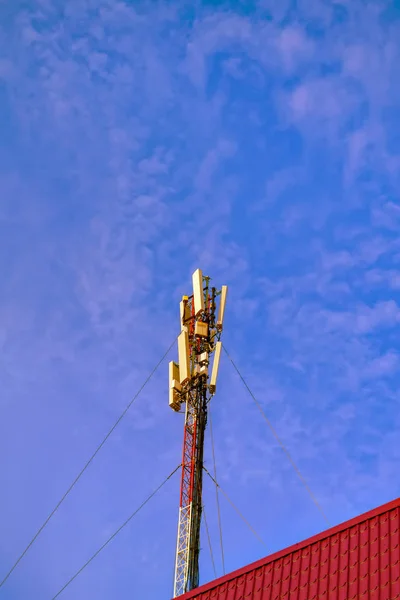 Telecommunications tower against blue spring sky and clouds. — Stock Photo, Image