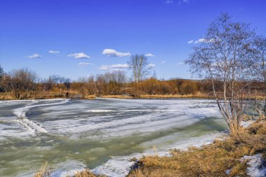 Erken Ilkbahar manzarası, köyün kenarındaki küçük bir nehirde buz eritir.