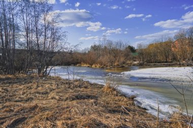 Erken Ilkbahar manzarası, köyün kenarındaki küçük bir nehirde buz eritir.