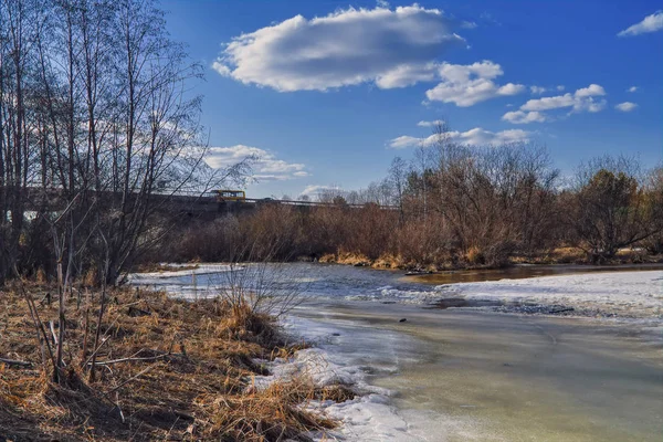 Tidig vår landskapet smälter isen på en liten flod i utkanten av byn. — Stockfoto