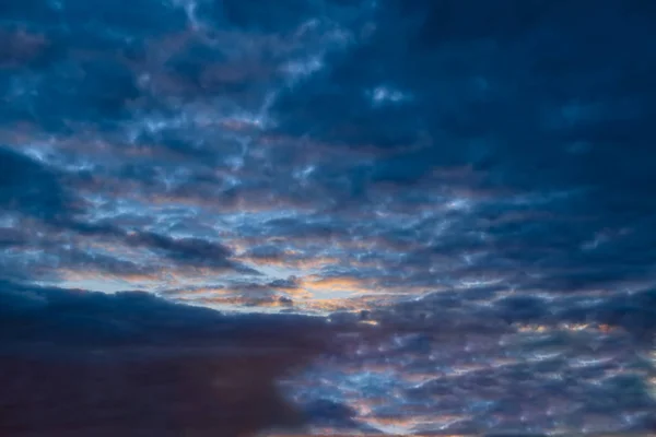 Blauwe hemel met gouden wolken - dramatische zonsondergang, mooie natuurlijke achtergrond. Instellen van de zon verlicht de wolken. — Stockfoto