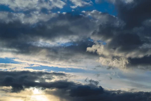 Cielo azul con nubes de oro - puesta de sol dramática, hermoso fondo natural. El sol poniente ilumina las nubes . — Foto de Stock