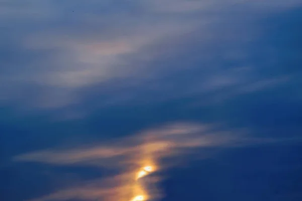 Blauwe hemel met gouden wolken - dramatische zonsondergang, mooie natuurlijke achtergrond. Instellen van de zon verlicht de wolken. — Stockfoto