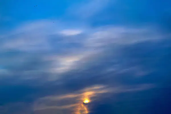 Blauwe hemel met gouden wolken - dramatische zonsondergang, mooie natuurlijke achtergrond. Instellen van de zon verlicht de wolken. — Stockfoto