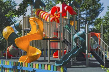 Sıcak güneşli bir yaz gününde bir şehir parkında boş oyun alanı.