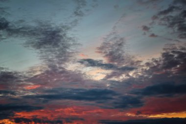 Batan güneşle aydınlatılmış kara bulutlarla gökyüzü