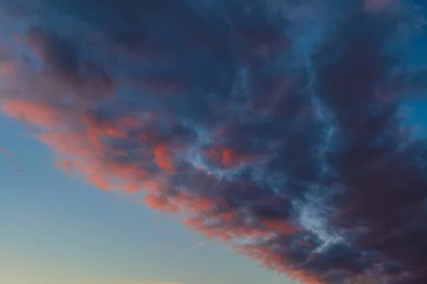 De hemel met donkere wolken verlicht door de ondergaande zon — Stockfoto