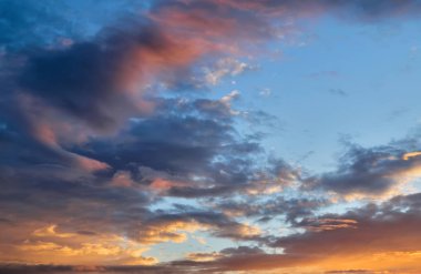 Gün batımında gökyüzü. Kümülüs bulutları batan güneşin ışınlarıyla aydınlatıldı.
