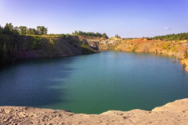 Açık şeffaf mavi su ile orman gölün kıyısında yaz manzara.