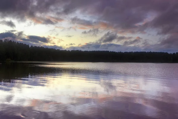 Paisagem de verão na margem de um lago florestal com água azul transparente clara. Pôr do sol . — Fotografia de Stock