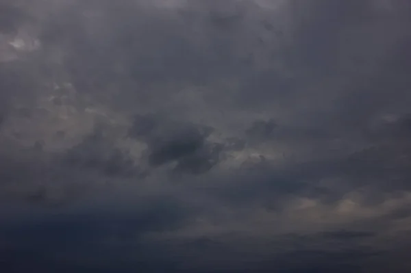 Mörka regnmoln under solnedgången. Dramatisk himmel under solnedgången. Mörka Storm moln med svarta och vita höjdpunkter. — Stockfoto